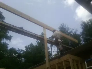 Carpenter setting a ridge beam over a new addition frame — Ice Dam Removal by Roofing Brothers in Mayport