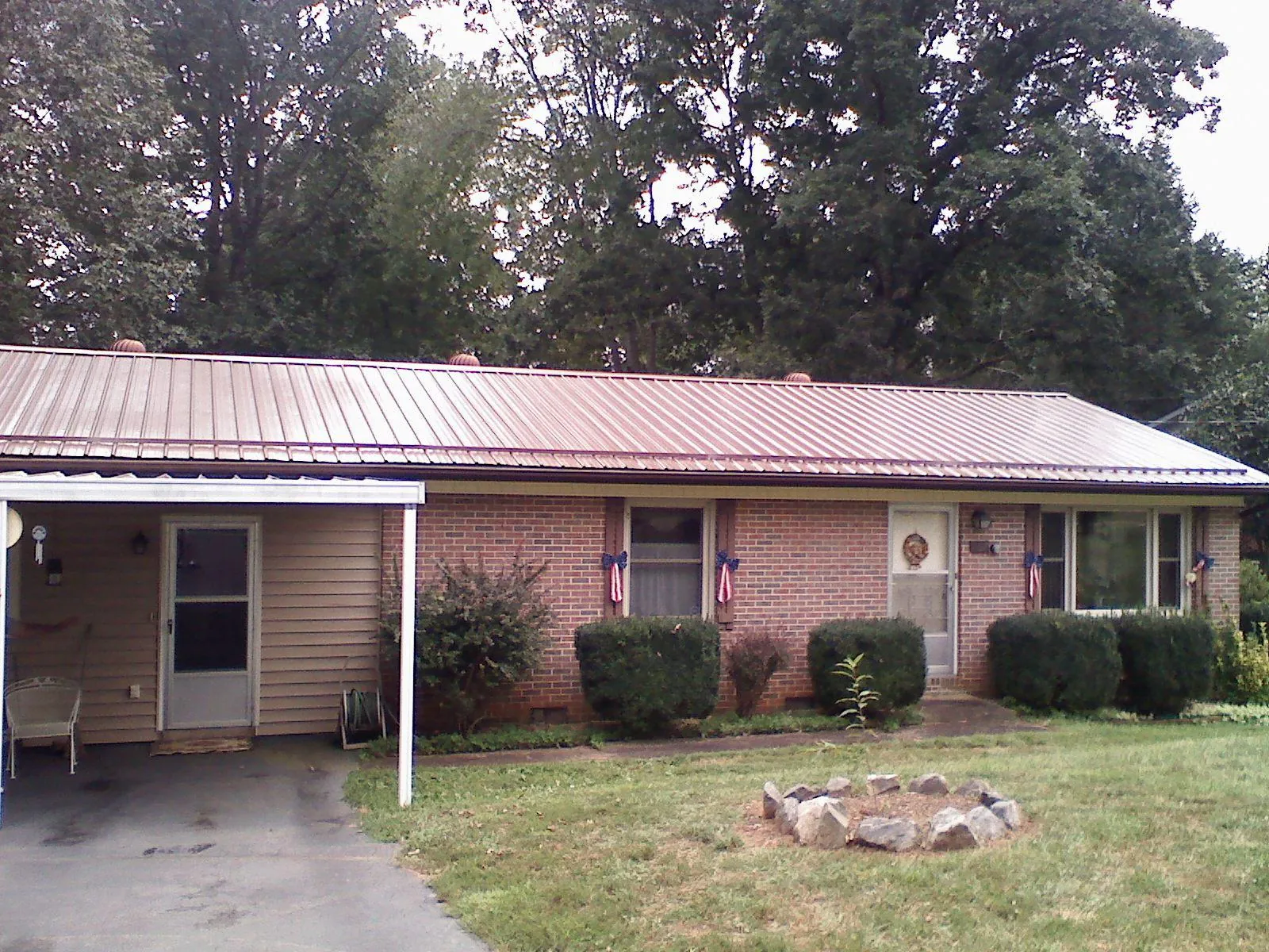 Bronze metal roof and carport on a brick ranch home — Roof Repair work by our crew in Mayport